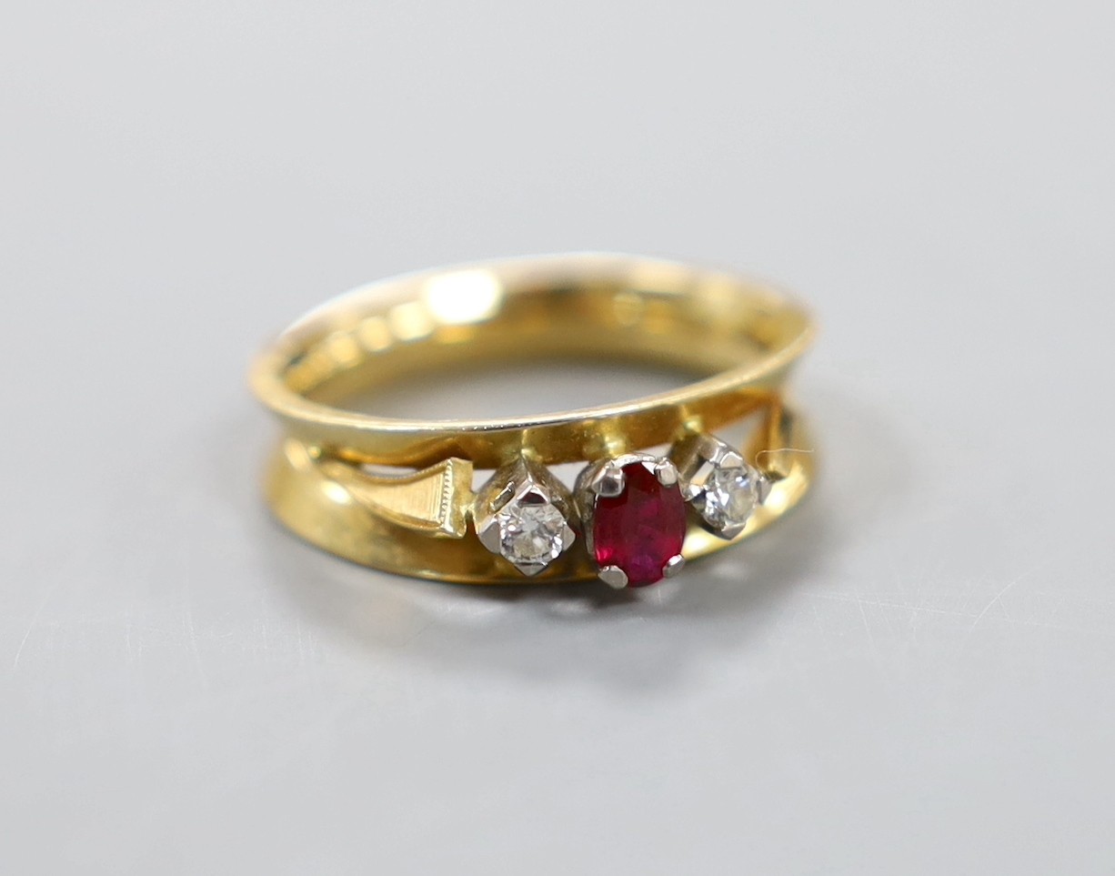 A modern 18ct, ruby and diamond set three stone ring, size Q, gross weight 5.7 grams.